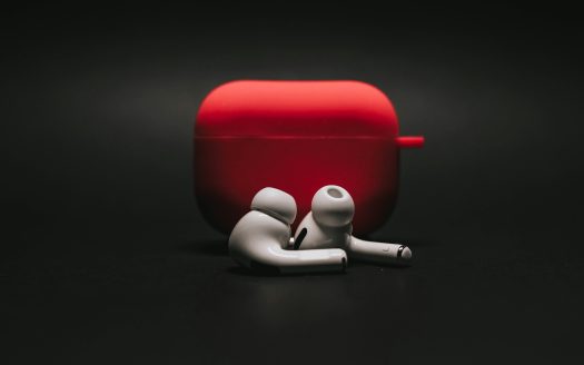 a pair of white plastic headsets next to a red case