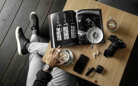 a person sitting at a table with a magazine and a book